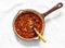 Classic homemade amatriciana tomato sauce in the cooking pan on a light background, top view. Pasta bucatini amatriciana tomato