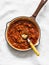 Classic homemade amatriciana tomato sauce in the cooking pan on a light background, top view. Pasta bucatini amatriciana tomato