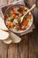 Classic homemade Italian soup with orzo pasta, chicken meatballs and vegetables close-up on a table. Vertical top view