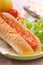 Classic hotdog full of chili sauce served with vegetables