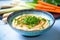 classic hummus in a bowl with carrot and celery sticks arranged around it