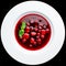 classic Italian food. Beautifully decorated plate with strawberries and raspberries in a ginger juice, dark background, top view