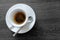 Classic italian single espresso in white cup isolated on grey wooden table from above.