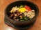 Classic Korea food vegetable Bibimbap hot stone pot,rice carrot,spinach,mushroom,cucumber,seaweed,raw yolk egg and hot spicy chili