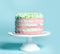 Classic light pink and blue stripes Birthday sweet cake with colorful sprinkles over a popular light turquoise mint on white