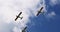 Classic light propeller planes flying in a sunny blue sky with white clouds
