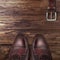 Classic male brown leather shoes with belt on wood