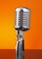 Classic microphone on orange background