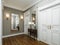 Classic modern hallway corridor interior with beige walls and white doors. Key table and a large mirror with sconces on the wall
