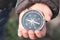 Classic navigation compass in childs hand on natural background