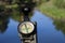 Classic navigation compass in summer against river as symbol of tourism