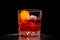 Classic Negroni in a crystal-cut rocks glass isolated on black backdrop
