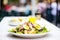 classic nicoise salad with a blurred restaurant background