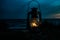 Classic oil lantern burning a bright flame at sunset on a beach