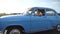 Classic old car traveling on highway on rainy summer day. Young couple driving on country road in vintage automobile