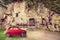 Classic old vintage red car. Archaeological area City of Sutri, Italy