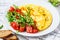 Classic omelet with cheese and tomatoes salad on white plate