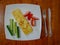 Classic omelet with tomatoes and cucumbers on the white plate.