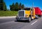 Classic orange big rig semi truck with red container on flat bed