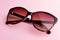 Classic oval oversized brown tortoise sunglasses closeup on pink background