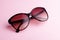 Classic oval oversized brown tortoise sunglasses closeup on pink background