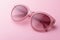 Classic oval oversized pink sunglasses closeup on pink background