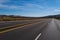 Classic panorama view of an endless straight road running through the barren scenery of the American Southwest.