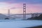 Classic panoramic view of famous Golden Gate Bridge seen from scenic Baker Beach in beautiful golden evening light on sunset.