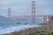 Classic panoramic view of famous Golden Gate Bridge seen from scenic Baker Beach in beautiful golden evening light on sunset.