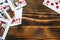 Classic playing cards on dark brown wooden table. Scattered cards.