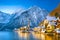 Classic postcard view of famous Hallstatt lakeside town in the Alps with traditional passenger ship on a beautiful cold sunny day