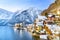 Classic postcard view of famous Hallstatt lakeside town in the Alps with traditional passenger ship on a beautiful cold sunny day