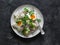 Classic potato salad with boiled egg, red onion and cilantro on a dark background, top view