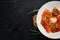 Classic Ravioli with Tomato Sauce and Parmesan Cheese. Italian cuisine. Dumplings. In a plate on a wooden background.
