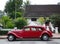 Classic red Citroen Traction Avant vintage car side view against backdrop of colonial heritage buildings