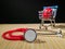 Classic red stethoscope and heart in a shopping cart on a simple organic bamboo table black background. Health care and medicine