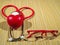 Classic red stethoscope and red plastic frame glasses on a simple organic bamboo table. Health care and medicine concept