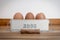 Classic retro cream coloured gloss egg tin tray holding six large free range fresh eggs in container with text on front