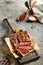 Classic ribeye steak served in waxed paper on wooden cutting board