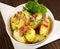 Classic Roasted Potatoes with Bacon and Onions in a Bowl on wooden Background