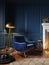 Classic royal blue color interior with armchair, fireplace, candle, floor lamp, carpet.