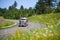 Classic semi truck big rig carrying lumber on highway