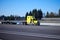 Classic semi truck yellow flat bed trailer on interstate highway