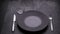 Classic serving tableware on the table, black plate fork and knife