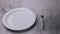 Classic serving tableware on the table, white plate fork and knife