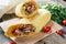 Classic shawarma with chicken and vegetables in pita bread on wooden dark background with cherry tomatoes and parsley