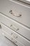 Classic silver handle on white drawers with depth of field