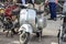 Classic silver metallic Vespa motorbike parked on display on a road