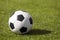 Classic soccer football ball on a grass pitch. Side view on retro classic football ball