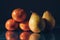 Classic still life image of mandarin and pear on a metal reflective surface. Dark background. Selective focus